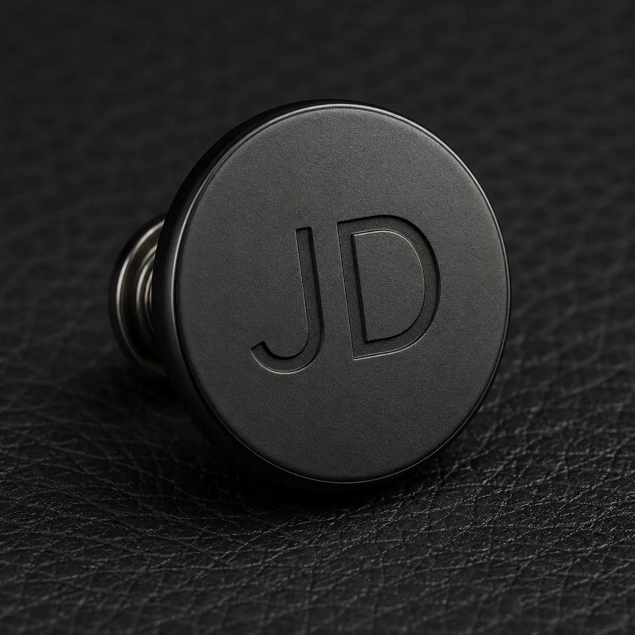 Matte black snap button engraved with JD.