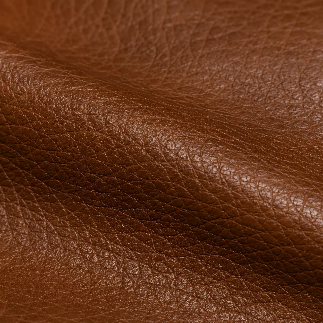 Close-up texture of goat hide brown leather material swatch for custom jackets.